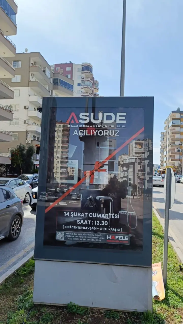 Cadde üzerindeki ışıklı panoya asılan açılış duyuru afişi.